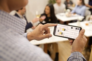 Restaurant manager using Carbonara on a phone during service