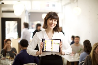 Server taking a reservation on a tablet